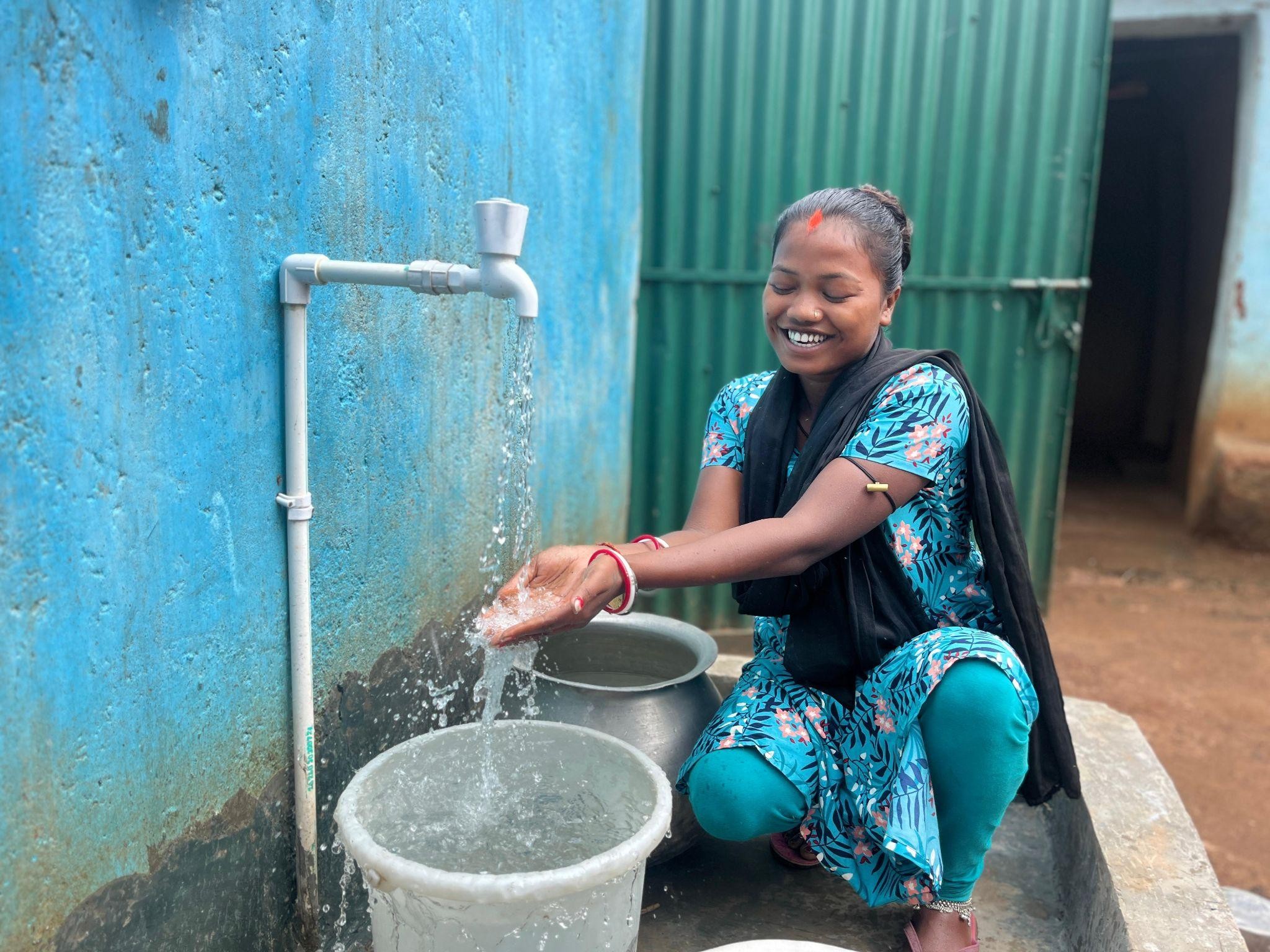 Sabhiya Tudu, resident of Binkarwa, celebrating the water access at her home. 
